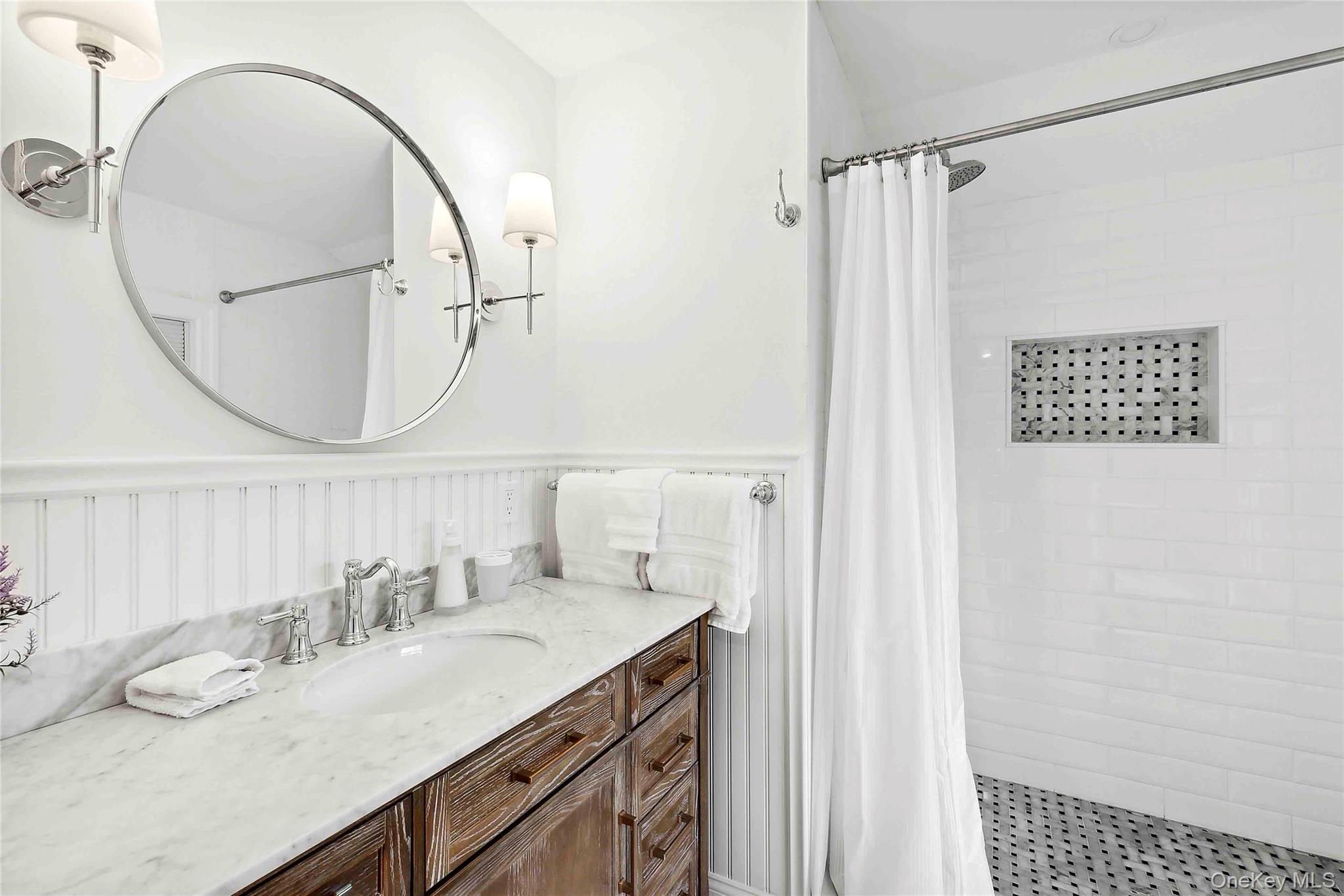 96 Miller Road Southampton, NY 11968 - Photo 5 of 18 a bathroom with a granite countertop sink a mirror and a shower