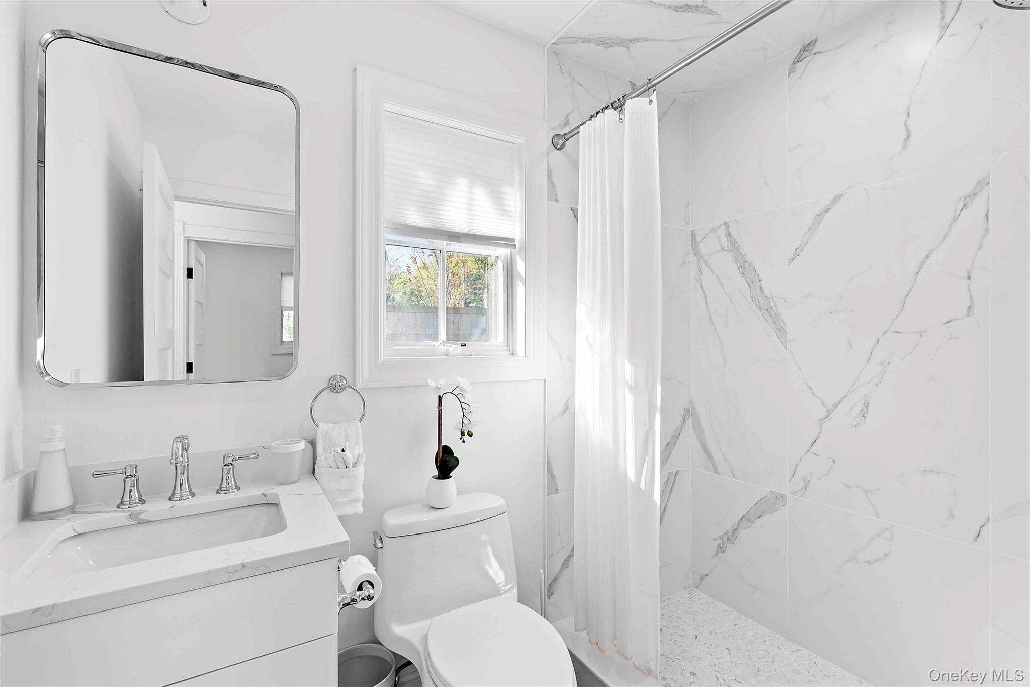 96 Miller Road Southampton, NY 11968 - Photo 10 of 18 a bathroom with a toilet sink vanity and mirror