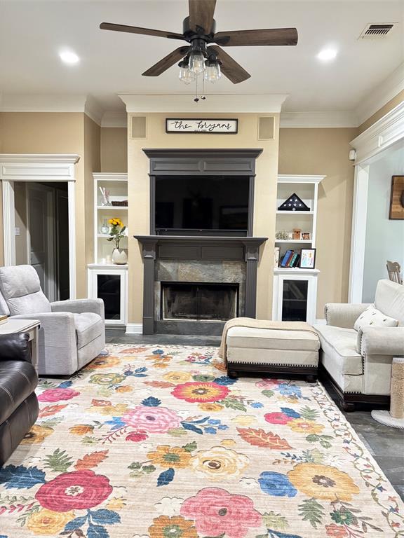 605 Jade Haughton, LA 71037 - Photo 3 of 34 Living area featuring a central fireplace with stone surround, flanked by built-in shelving units, and crown molding