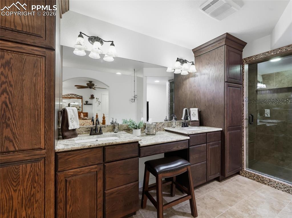 12855 Murphy Road Elbert, CO 80106 - Photo 30 of 50 a bathroom with a granite countertop sink a mirror and a shower
