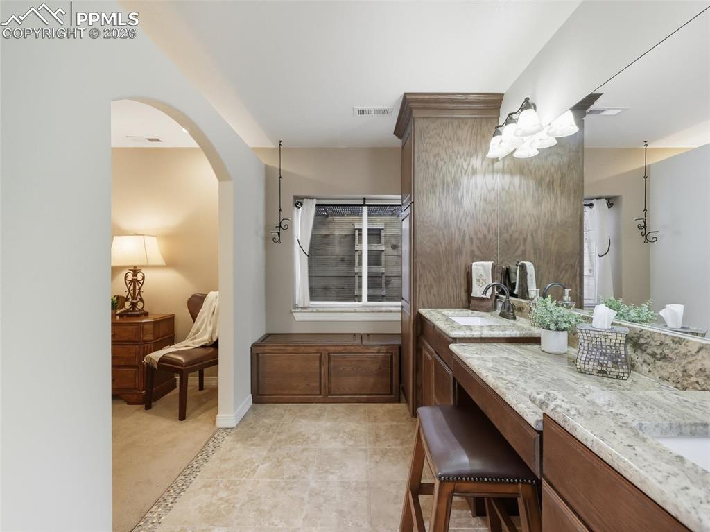 12855 Murphy Road Elbert, CO 80106 - Photo 32 of 50 a bathroom with a granite countertop sink a toilet and a mirror