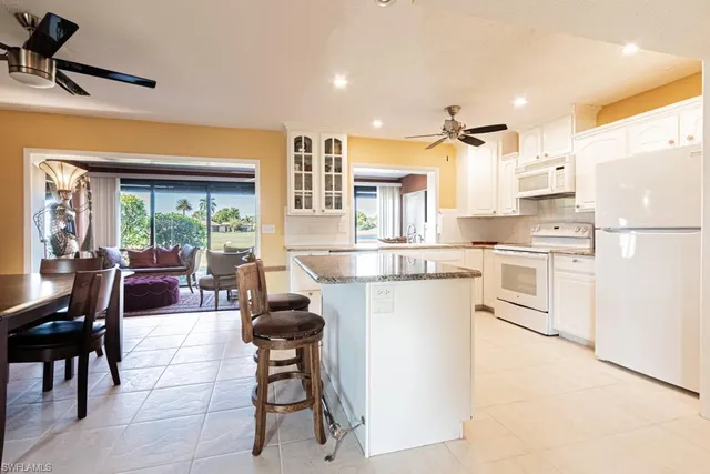 a kitchen with white cabinets and white appliances