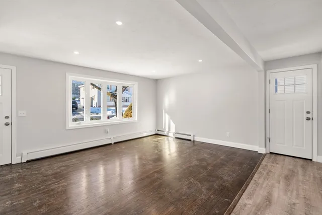 an empty room with wooden floor and window