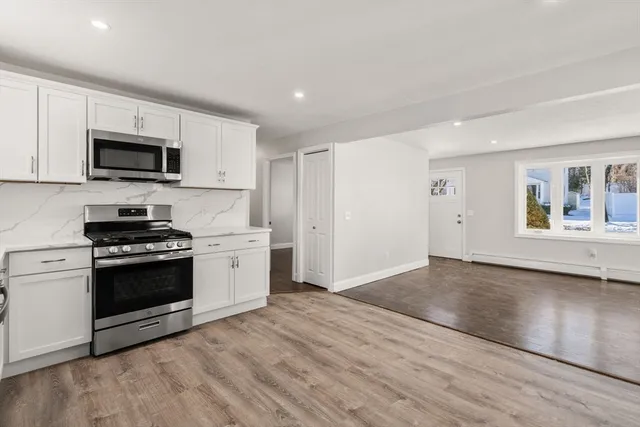 a kitchen with stainless steel appliances granite countertop a stove a sink and a microwave