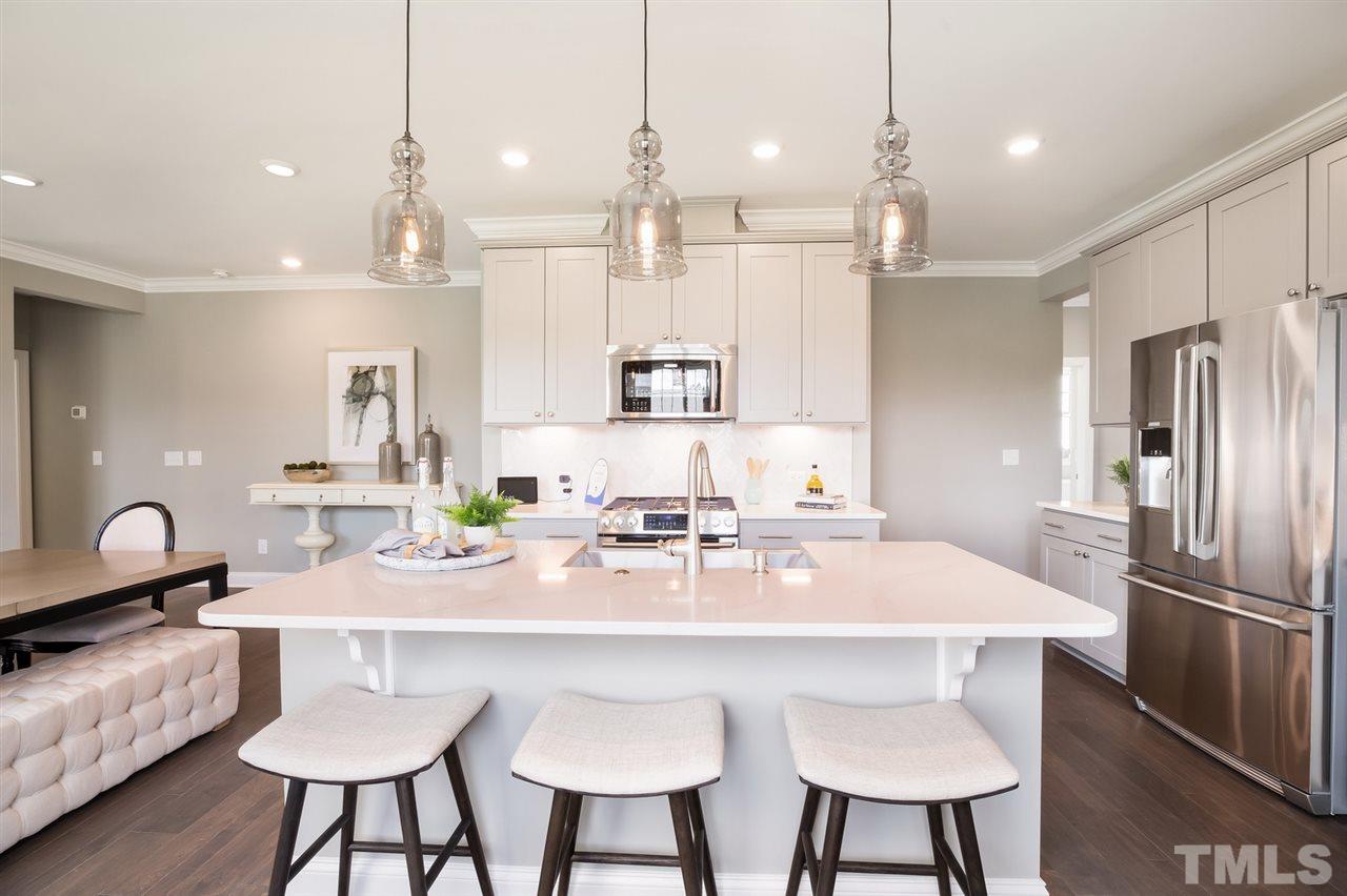 244 Mahogany Run, Unit 192 Raleigh, NC 27610 - Photo 13 of 30 a kitchen with kitchen island granite countertop a table and chairs