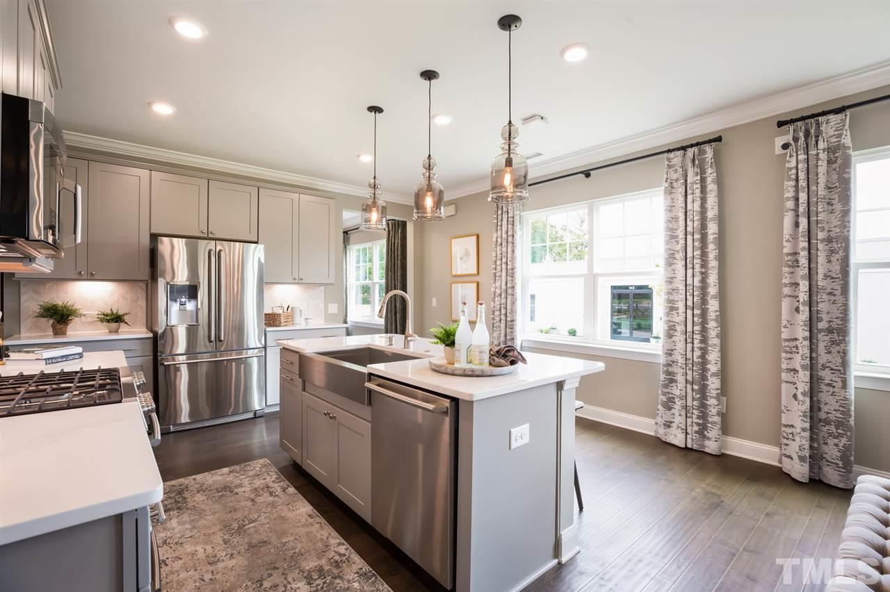 244 Mahogany Run, Unit 192 Raleigh, NC 27610 - Photo 15 of 30 a kitchen with stainless steel appliances granite countertop a stove a refrigerator a sink a oven with wooden floor