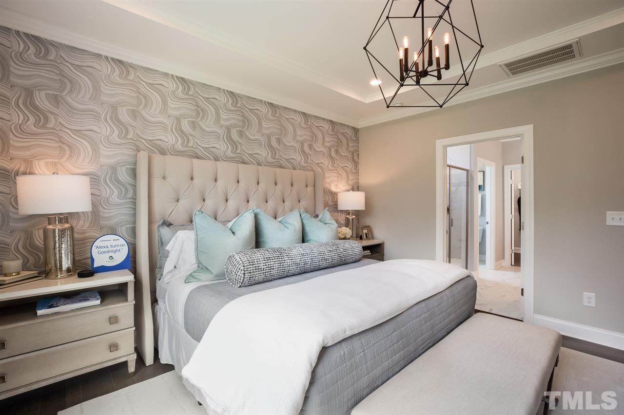 244 Mahogany Run, Unit 192 Raleigh, NC 27610 - Photo 20 of 30 a bedroom with a large bed and a chandelier