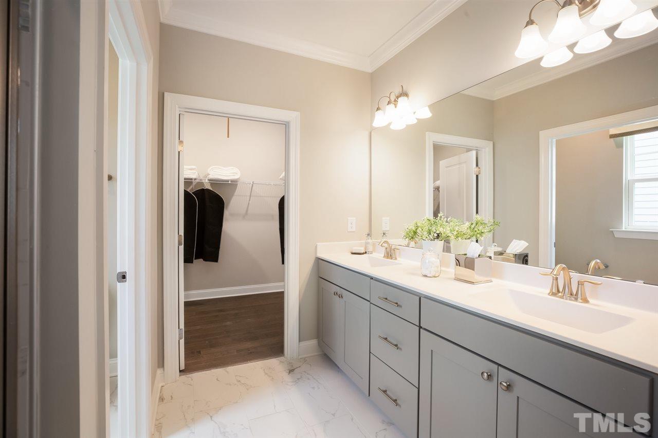 244 Mahogany Run, Unit 192 Raleigh, NC 27610 - Photo 21 of 30 a bathroom with a double vanity sink and a mirror
