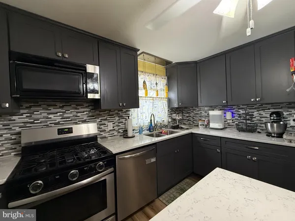 a kitchen with a sink stove and microwave