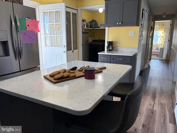 a kitchen with a sink a refrigerator and wooden floor