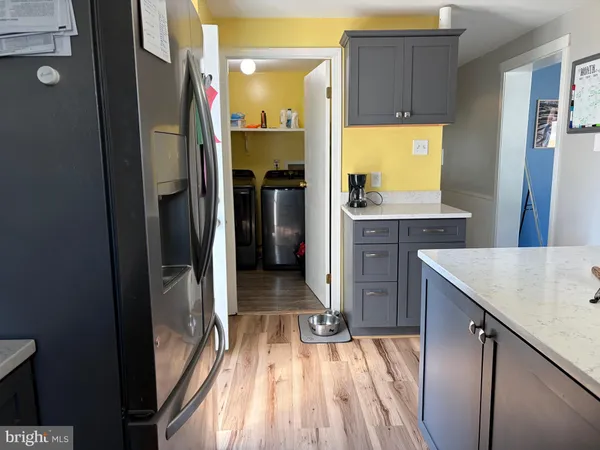 a kitchen with kitchen island wooden floor and refrigerator