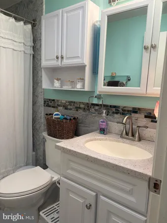 a bathroom with a sink a toilet and a mirror