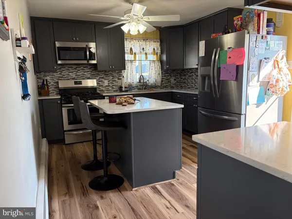 a kitchen with stainless steel appliances granite countertop a refrigerator and a stove top oven