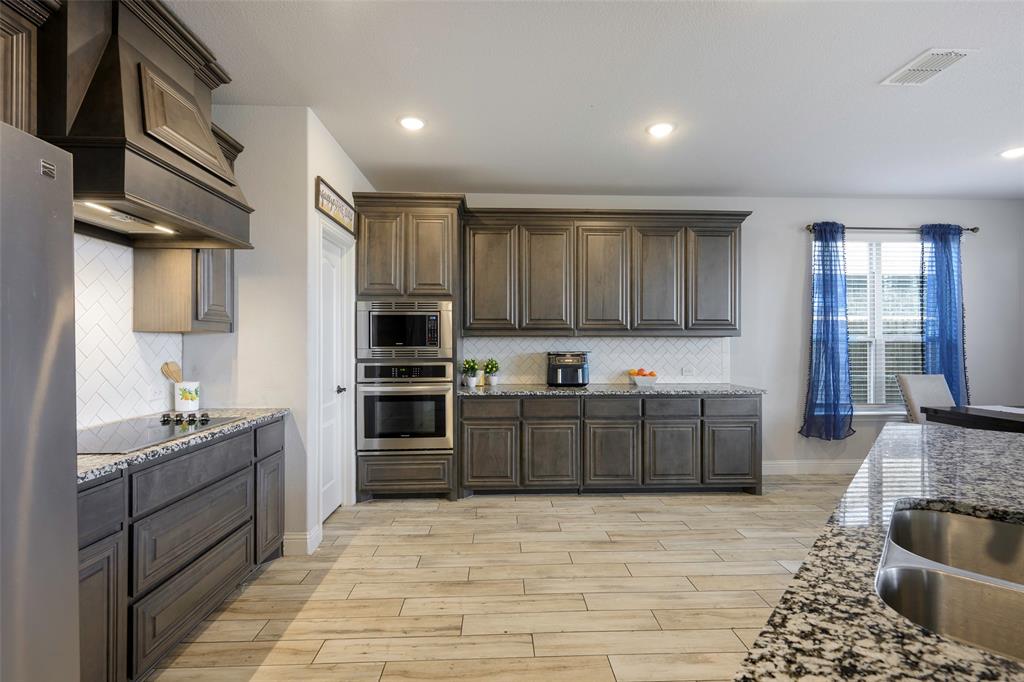4059 Three Forks Road Kaufman, TX 75142 - Photo 7 of 25 a kitchen with stainless steel appliances kitchen island granite countertop a refrigerator stove and sink