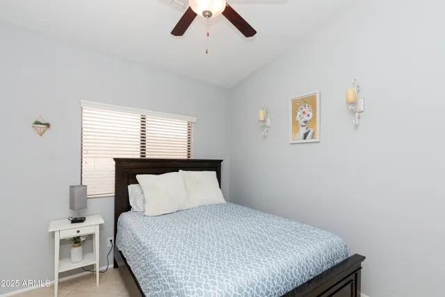 a bedroom with a bed and painting on the wall