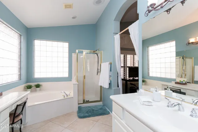 a bathroom with a bathtub a sink a mirror and a window