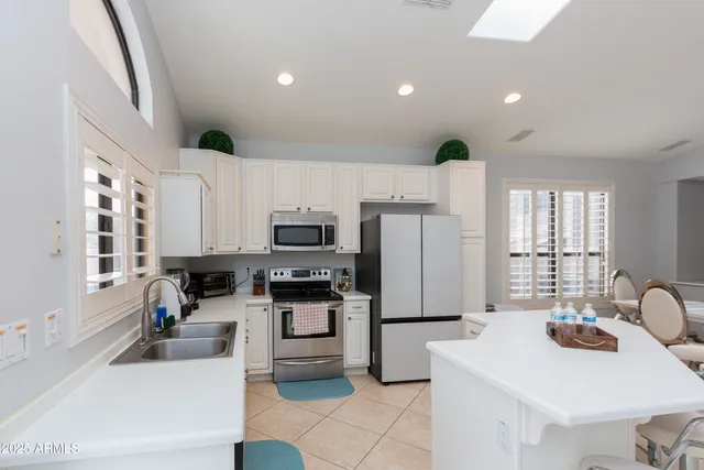 a kitchen with stainless steel appliances a stove a sink a microwave and a refrigerator