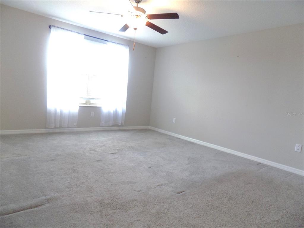 9411 Lemon Drop Loop Sun City Center, FL 33573 - Photo 24 of 47 an empty room with windows and fan