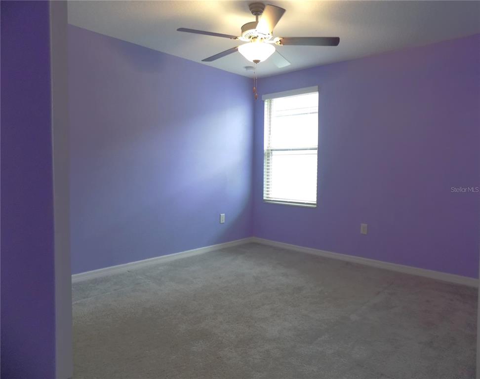 9411 Lemon Drop Loop Sun City Center, FL 33573 - Photo 30 of 47 an empty room with a window and a fan