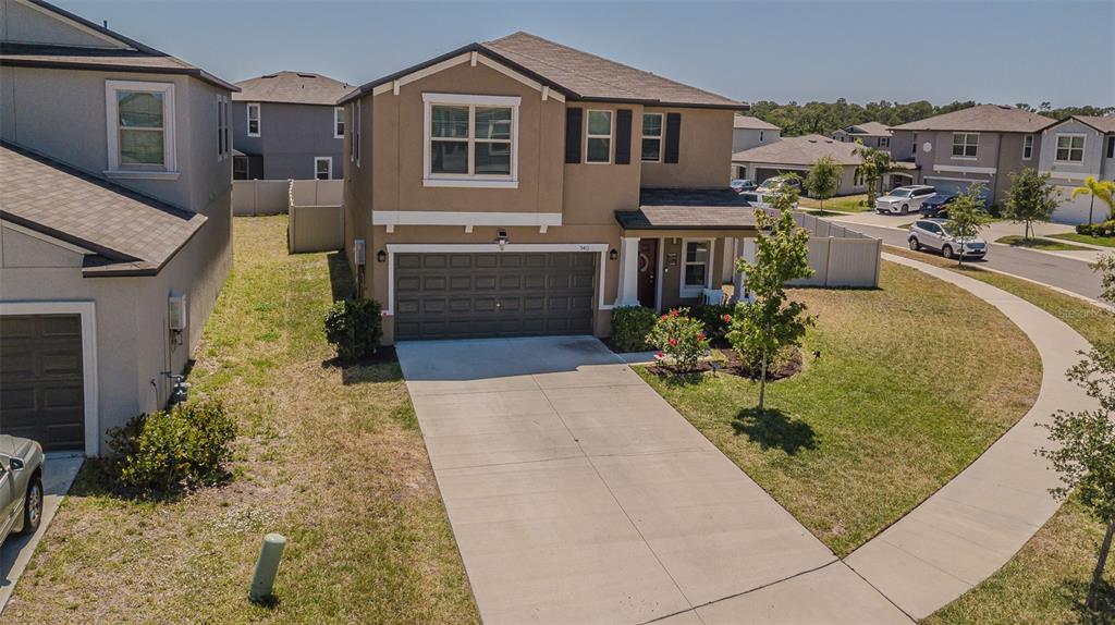 9411 Lemon Drop Loop Sun City Center, FL 33573 - Photo 3 of 47 a front view of a house with garden