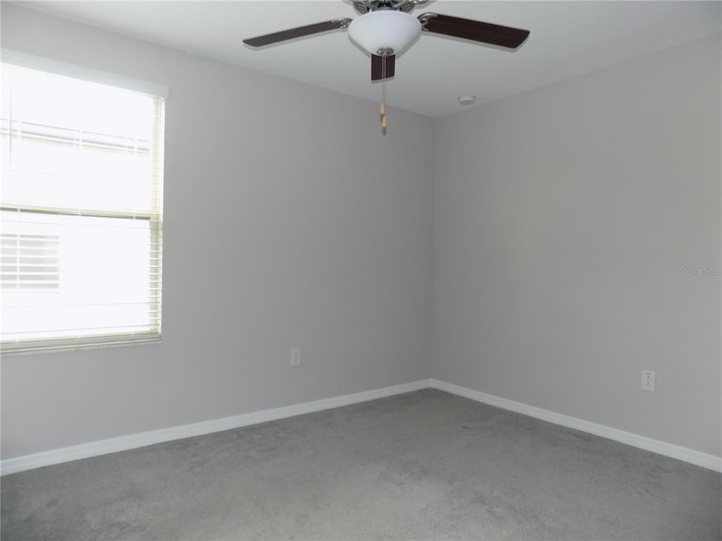 9411 Lemon Drop Loop Sun City Center, FL 33573 - Photo 34 of 47 an empty room with a window with a fan