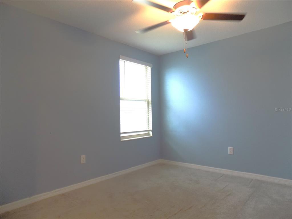 9411 Lemon Drop Loop Sun City Center, FL 33573 - Photo 40 of 47 an empty room with a window and a fan