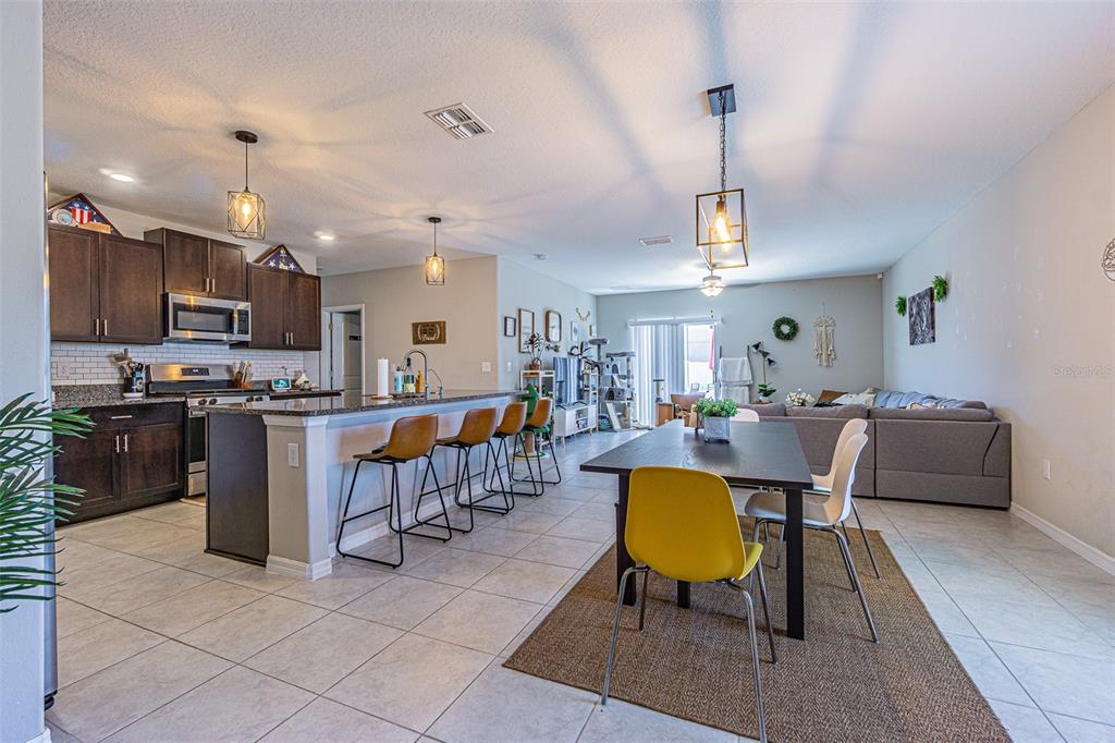 9411 Lemon Drop Loop Sun City Center, FL 33573 - Photo 6 of 47 a living room with lots of furniture kitchen view and a chandelier