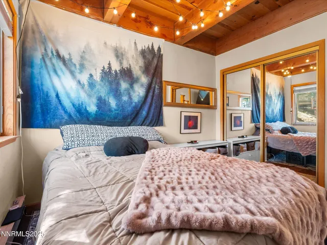 a bedroom with a large bed and a large window with outer view