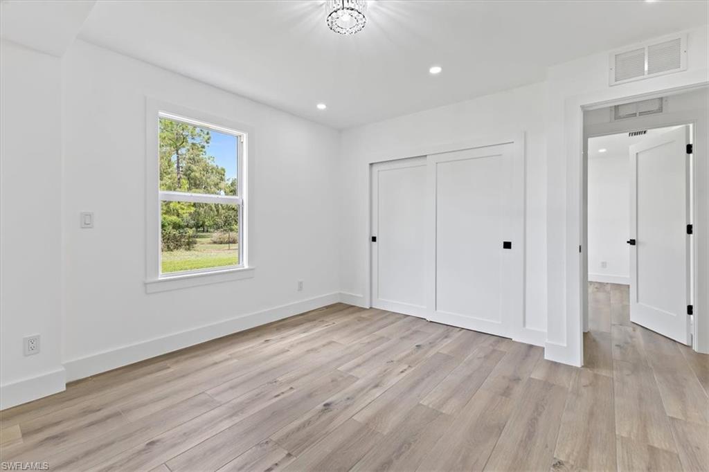 261 13th Street Southwest Naples, FL 34117 - Photo 12 of 35 Unfurnished bedroom with a closet and light hardwood / wood-style flooring
