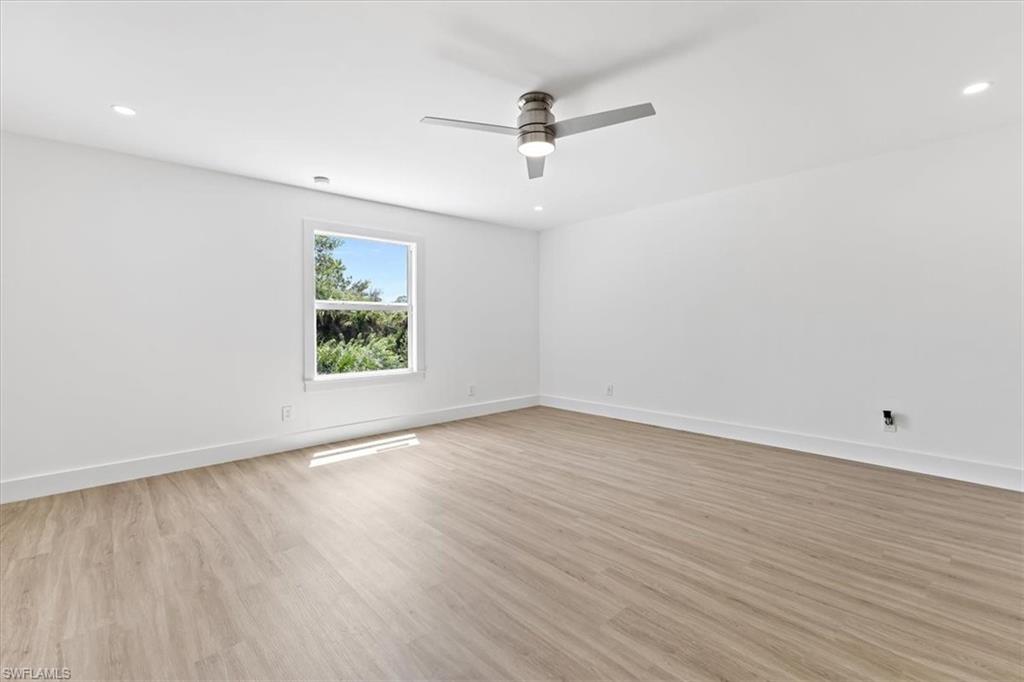 261 13th Street Southwest Naples, FL 34117 - Photo 22 of 35 Empty room with ceiling fan and light hardwood / wood-style floors