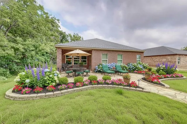 a front view of a house with a big yard and potted plants