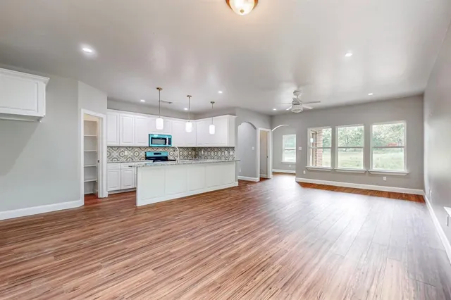 a view of kitchen with refrigerator and wooden floor