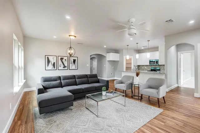 a living room with furniture and a wooden floor
