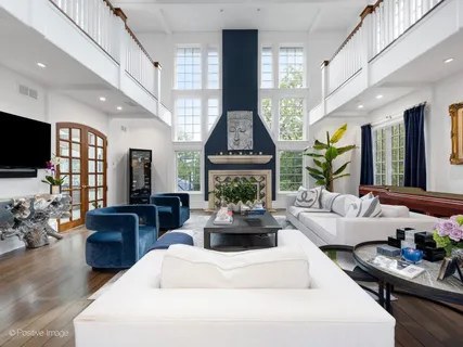 a living room with fireplace furniture and a large window