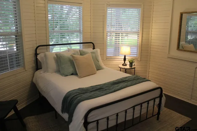 a bedroom with a bed and windows