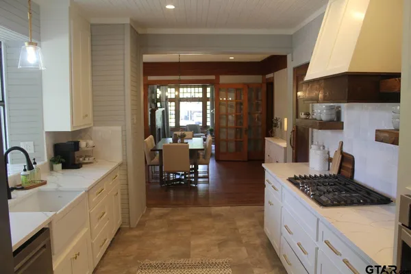 a kitchen with sink a stove and chairs