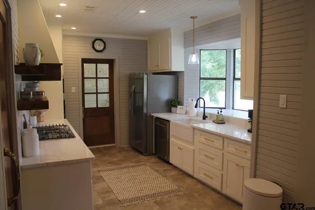 a kitchen with stainless steel appliances a refrigerator sink and cabinets