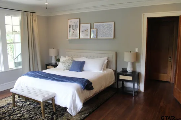 a bedroom with a bed a mirror and a window