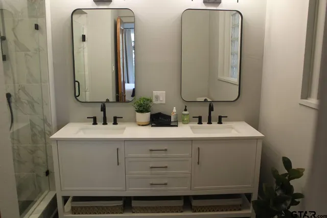 a bathroom with double vanity sinks and a mirror