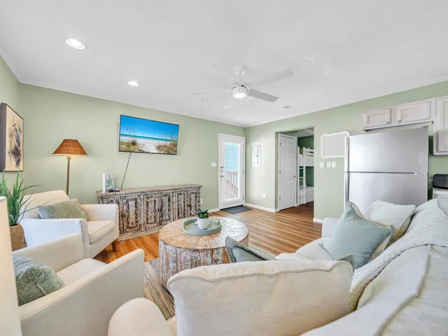 a living room with stainless steel appliances a dining table and kitchen view