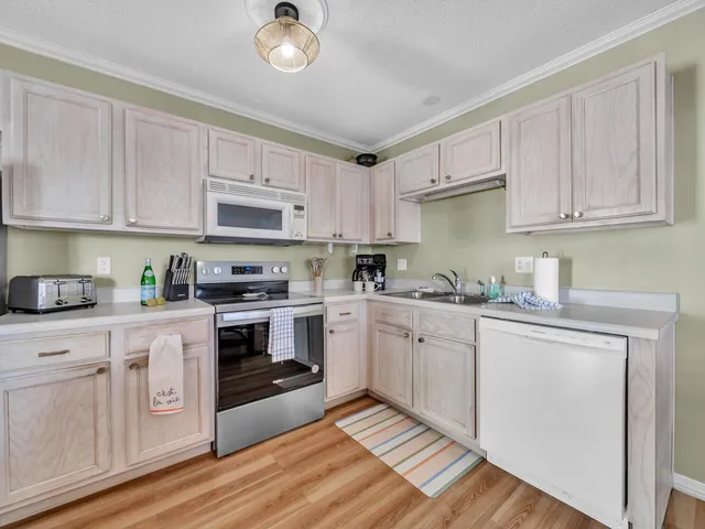 a kitchen with stainless steel appliances granite countertop a refrigerator stove top oven and sink