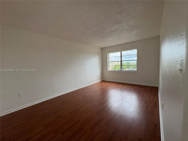 a view of an empty room and wooden floor