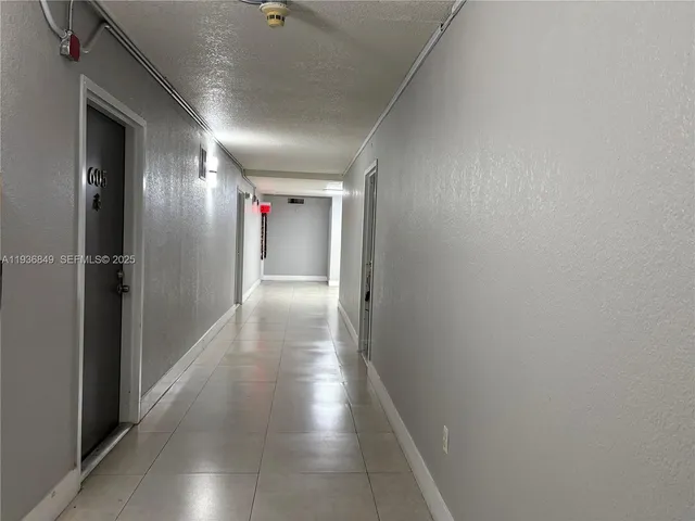 a hallway with wooden floor windows and stairs