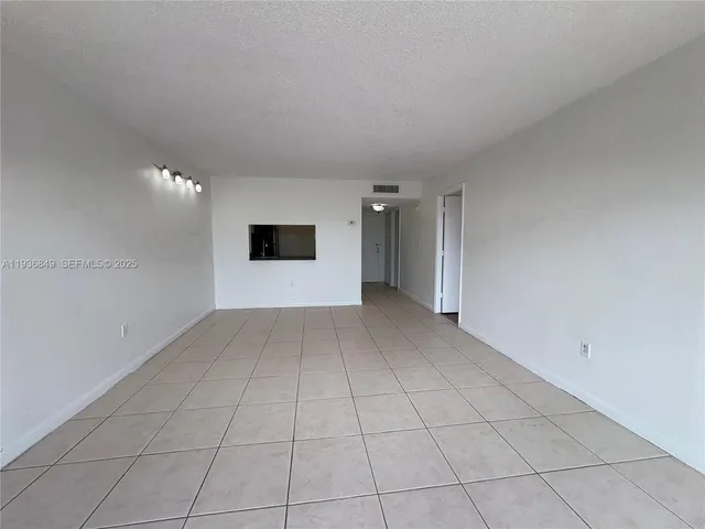 a view of a livingroom with wooden floor and a hallway