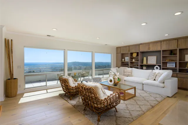 a living room with furniture and large windows