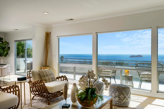 a living room with furniture and floor to ceiling windows