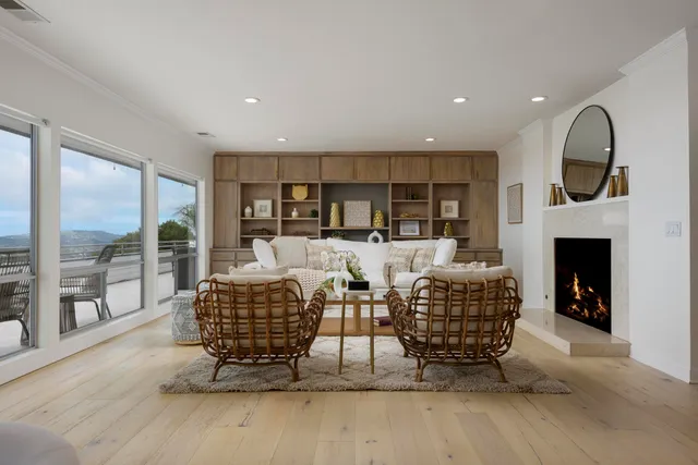 a living room with furniture a fireplace and a floor to ceiling window