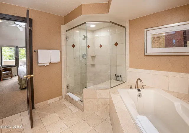 a bathroom with a tub shower and sink
