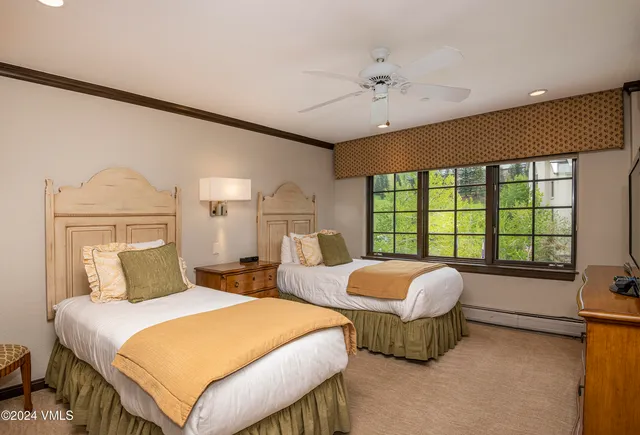 a bedroom with two beds and a large window