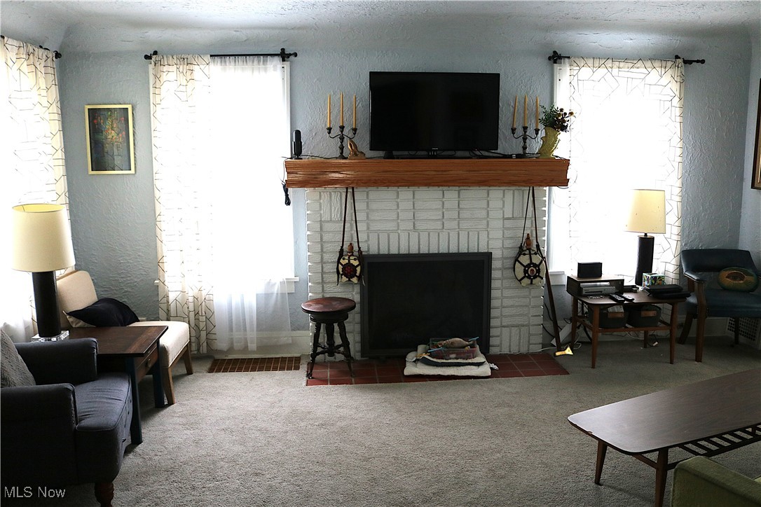 8233 Midland Road Mentor, OH 44060 - Photo 13 of 18 Carpeted living room with a textured wall and a brick fireplace